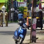Police controlling the people who are visiting the shops in the containment zone at Palarivattom area in Kochi.