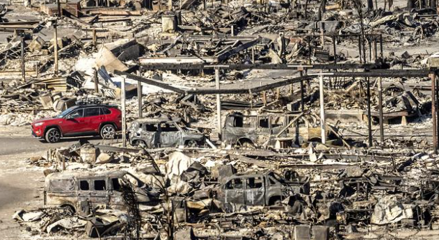 Los Angeles firefighters combat wildfires in an effort to protect homes and prevent further destruction amid strong winds.