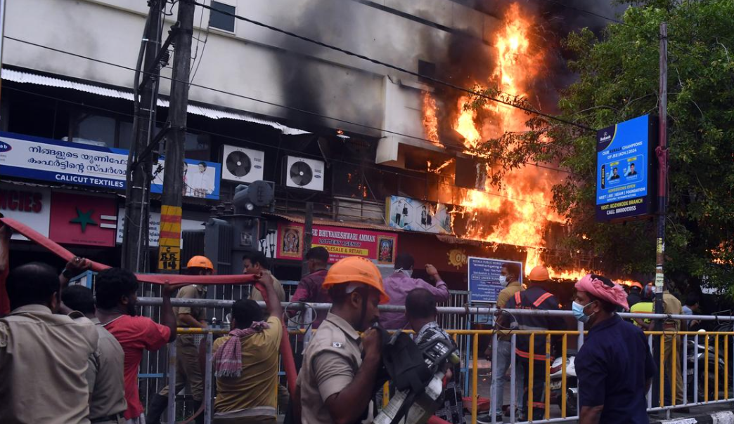 Firefighters at a burning shopping complex in Kozhikode, responding to a major fire